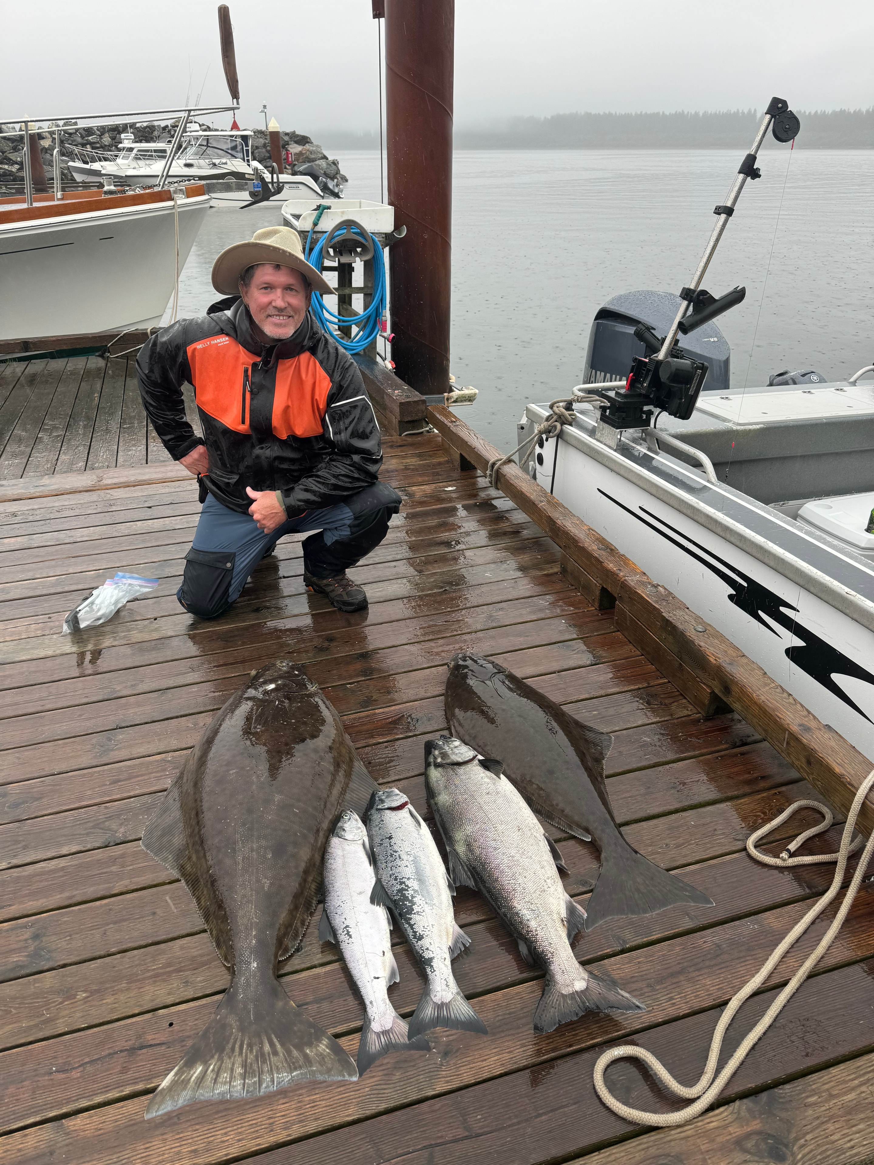 Angler on dock with halibut and salmon catch
