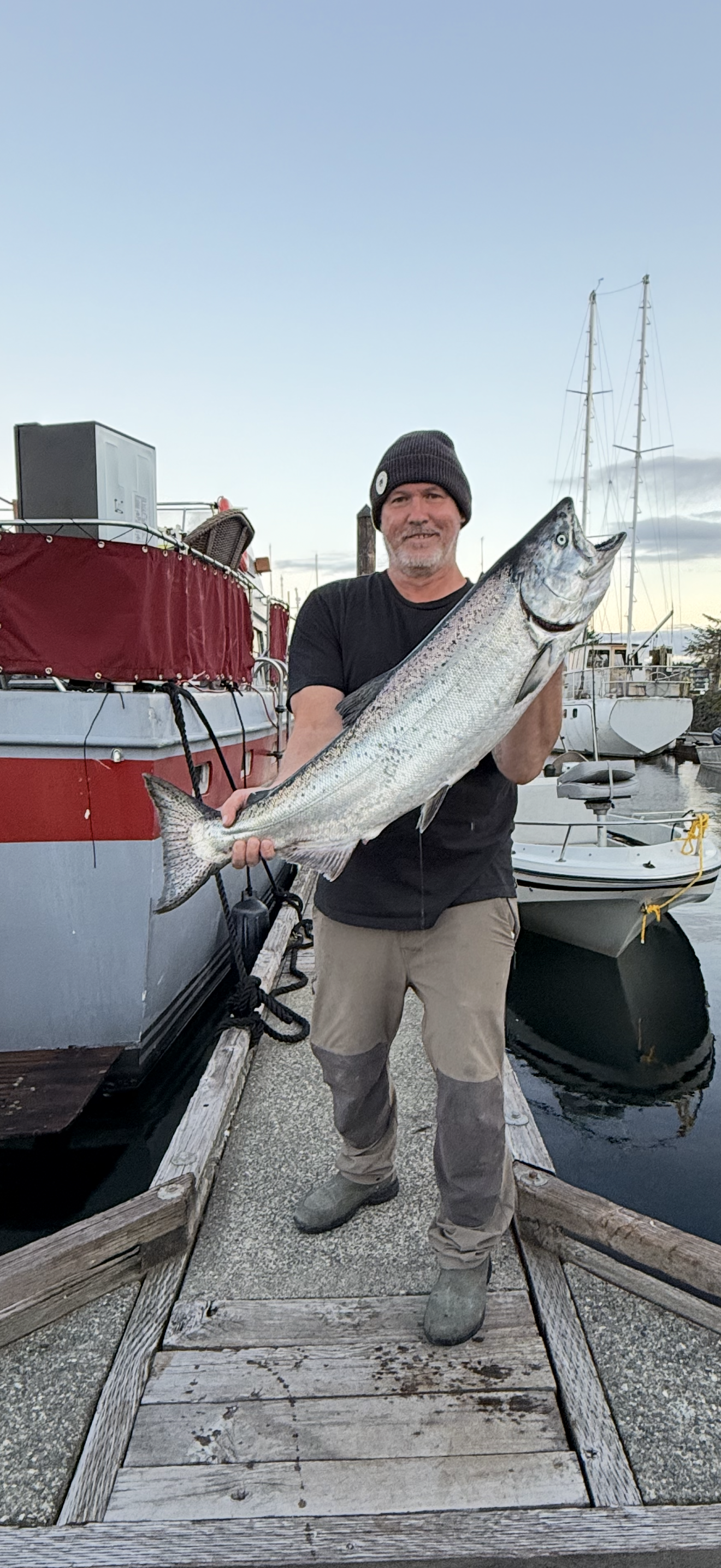 Angler holding large salmon at marina