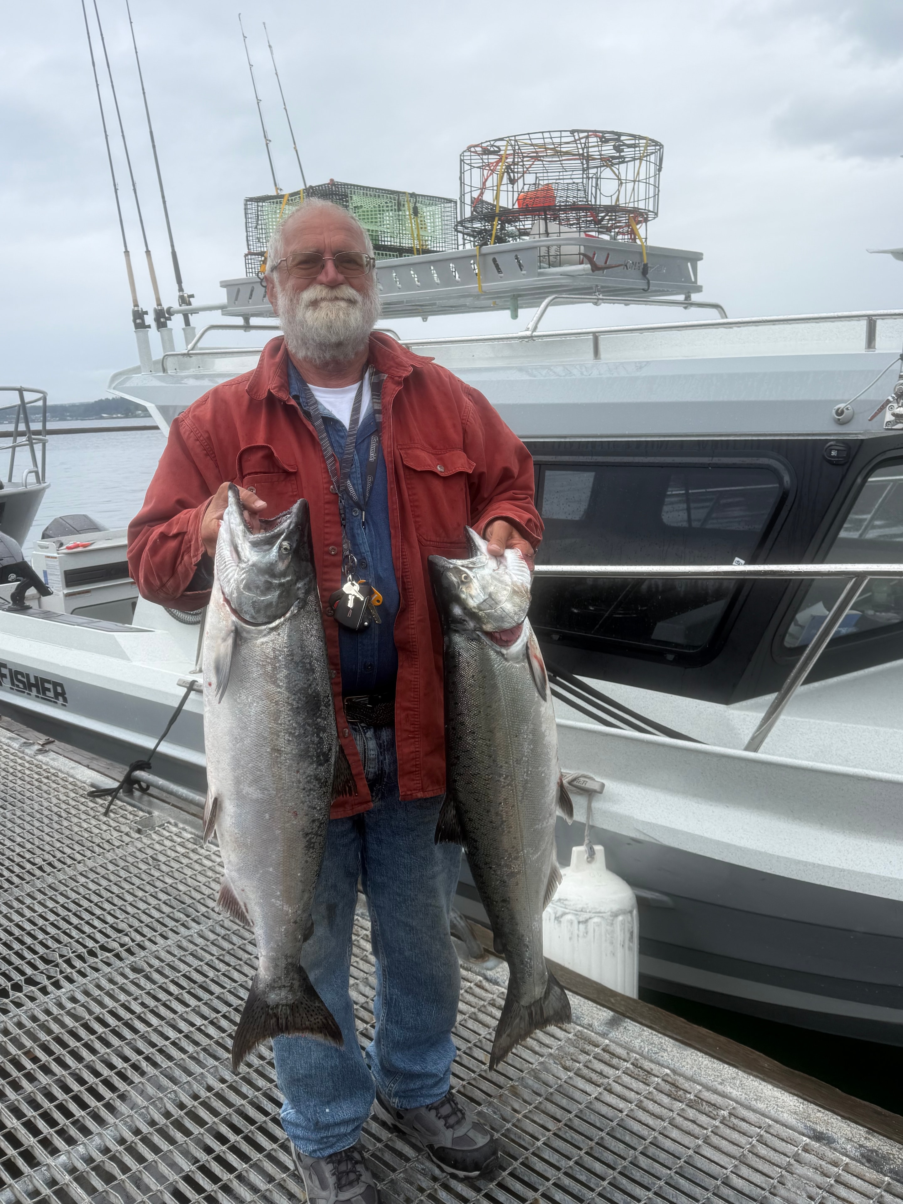 Angler holding two large salmon beside the boat